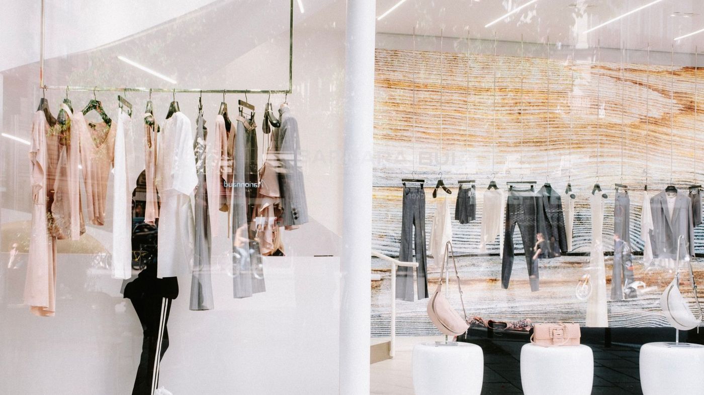 Clothing on racks inside a bright retail boutique