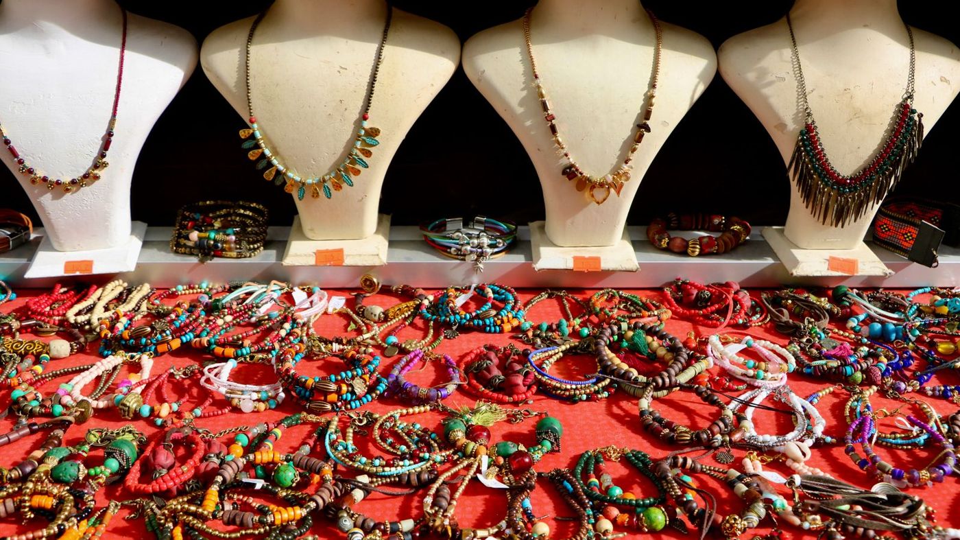 Necklaces displayed on busts at a jewelry stall